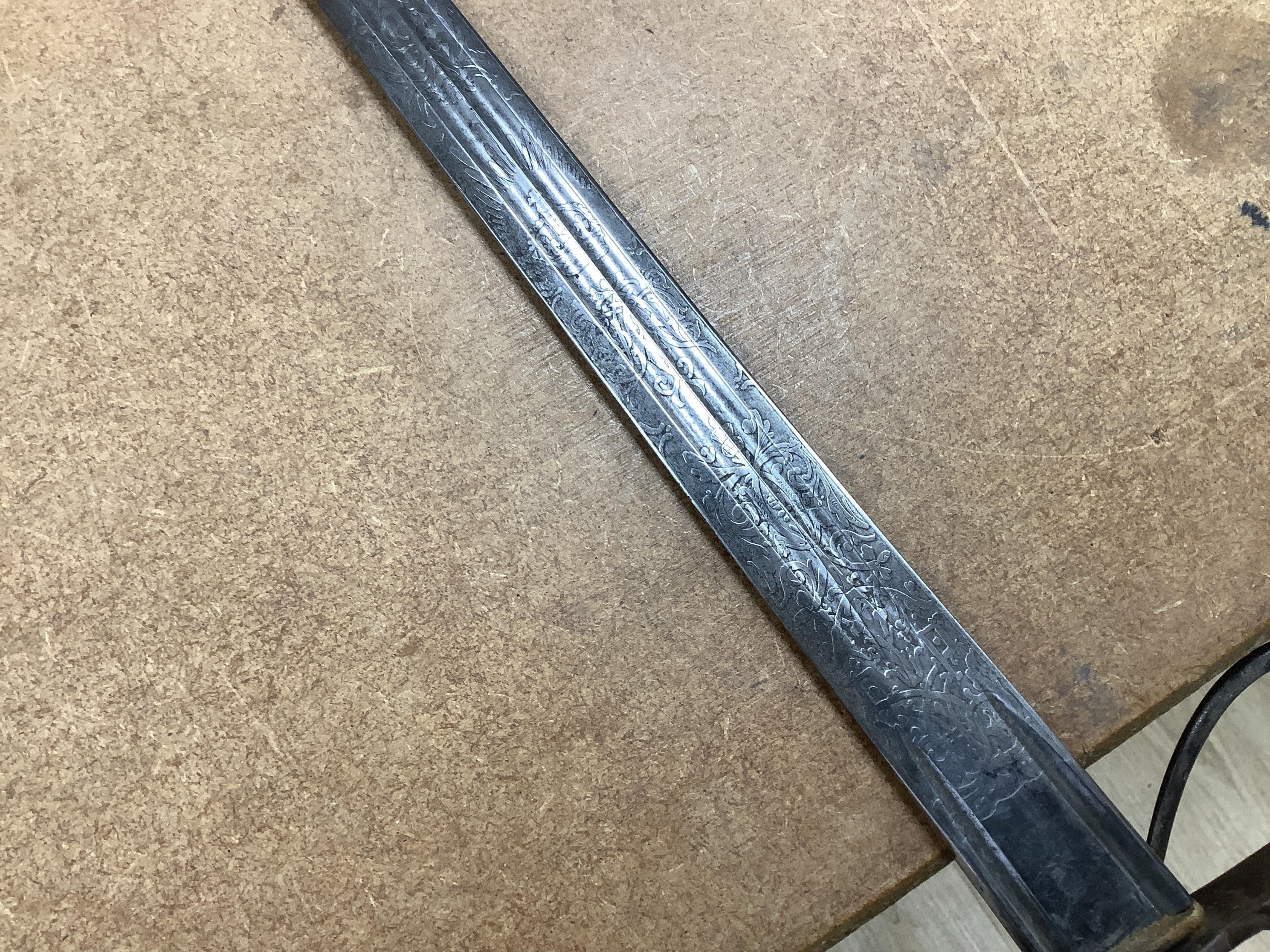 A late Victorian officer’s sword of the Black Watch, claymore blade etched with regimental title and VR cipher, regulation basket hilt, fish skin covered grip, in its leather covered field service scabbard, blade 82cm. C